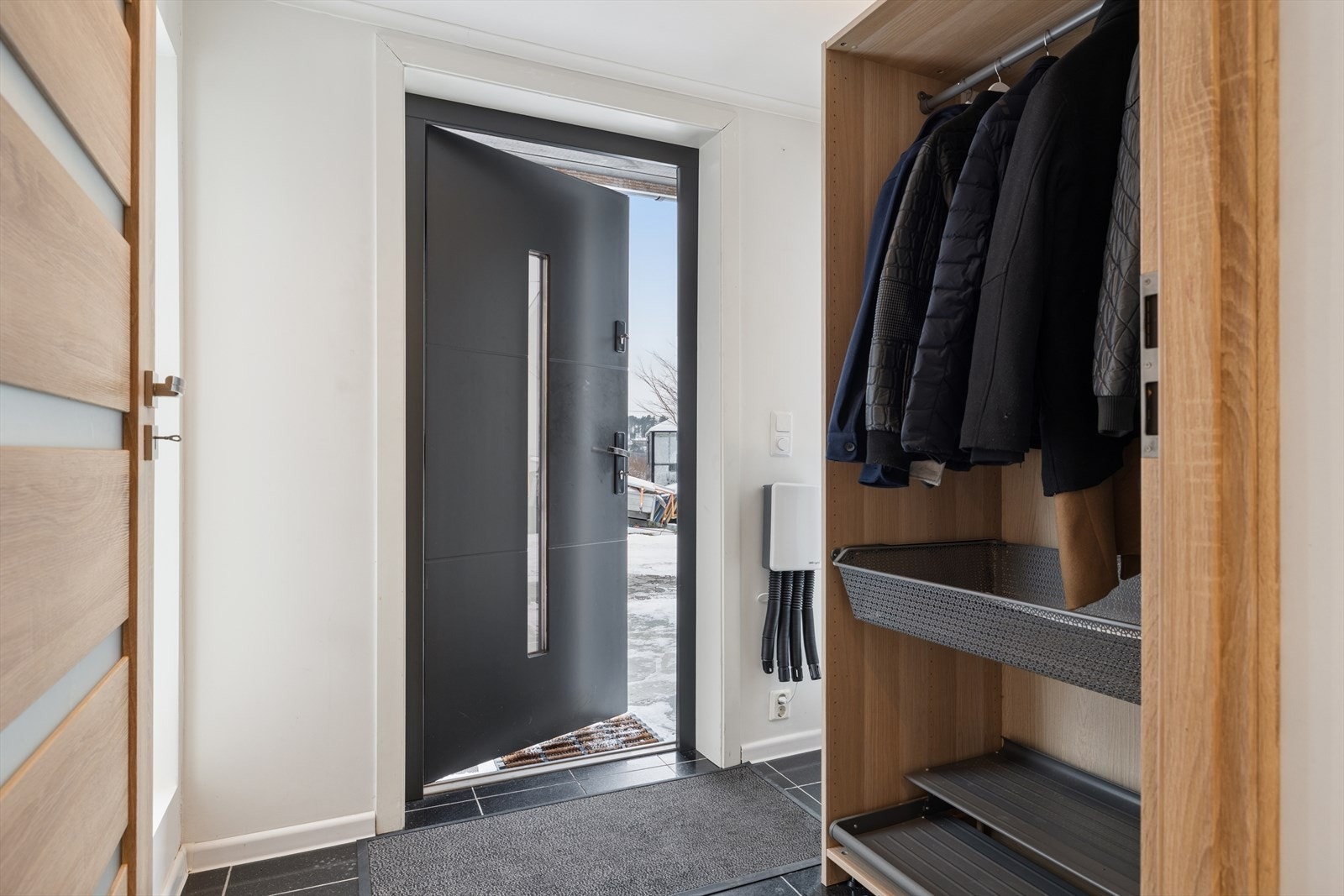 Åpen garderobeløsning gir praktisk oppbevaring i entréen. Galleribilde