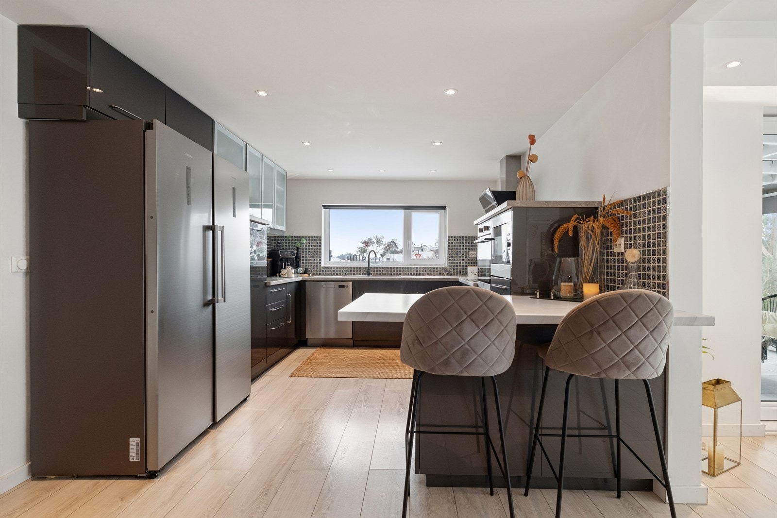 Kjøkkeninnredning fra 2020 med slette fronter og laminert benkeplate, utstyrt med komposittkum og ettgreps blandebatteri. Galleribilde