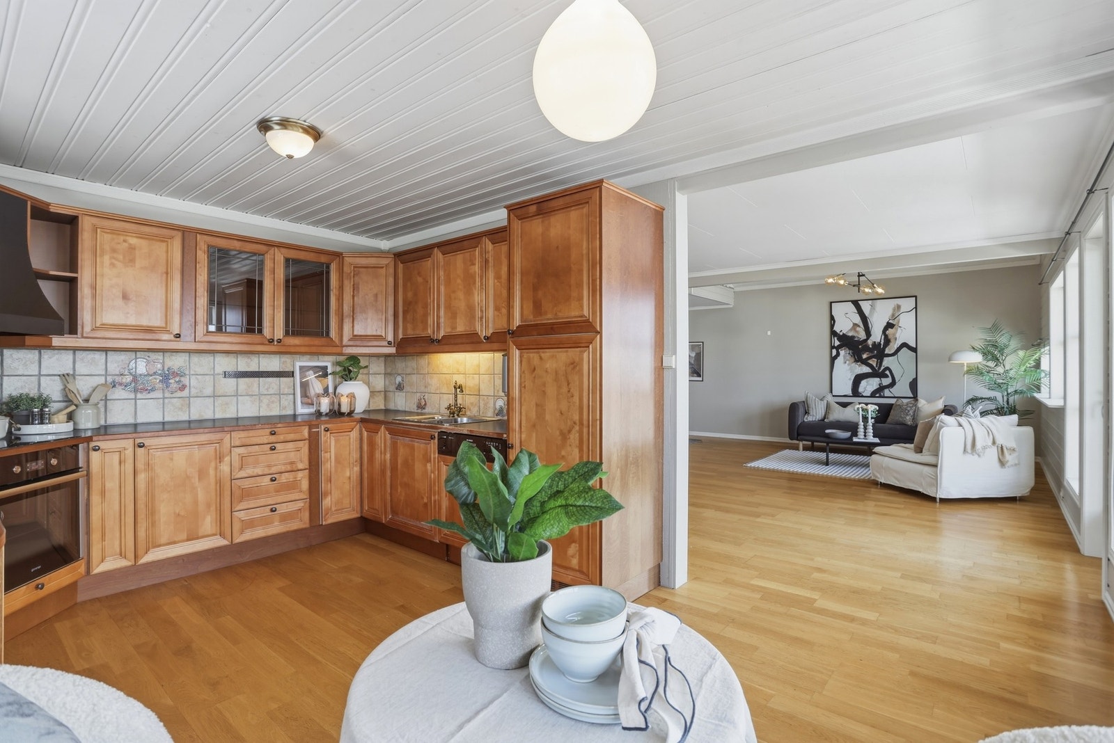 Kjøkken med integrerte hvitevarer og plass til kjøkkenbord Galleribilde