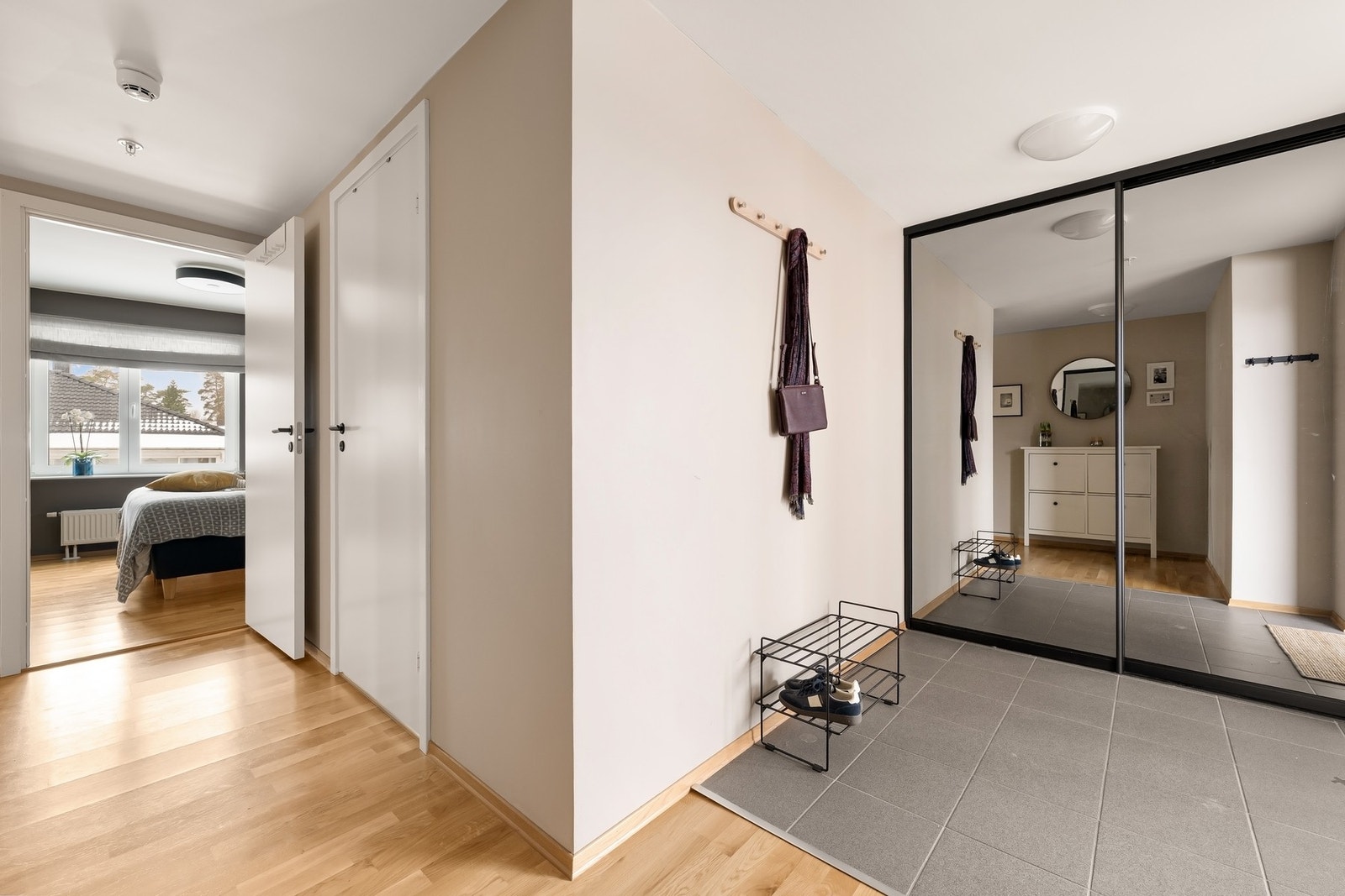 Romslig entre med flislagt gulv, praktisk skyvedørsgarderobe og plass til skohylle Galleribilde