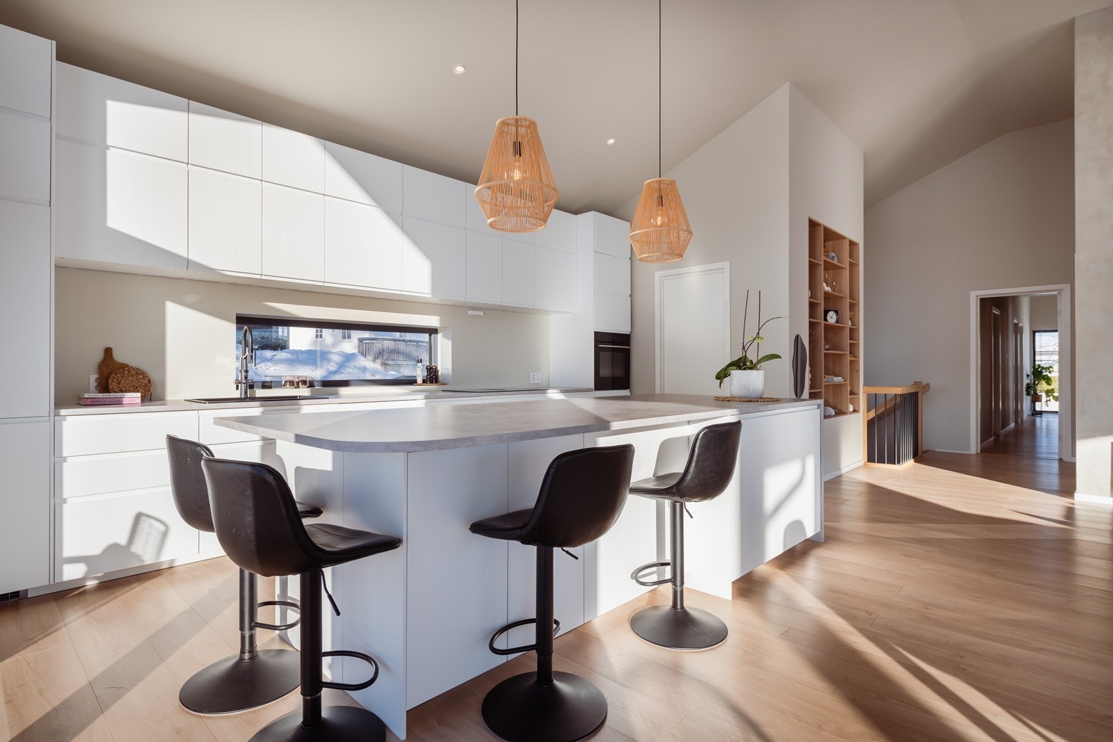 Stilrent kjøkken med stor kjøkkenøy som gir godt med benkplass til matlaging. Galleribilde