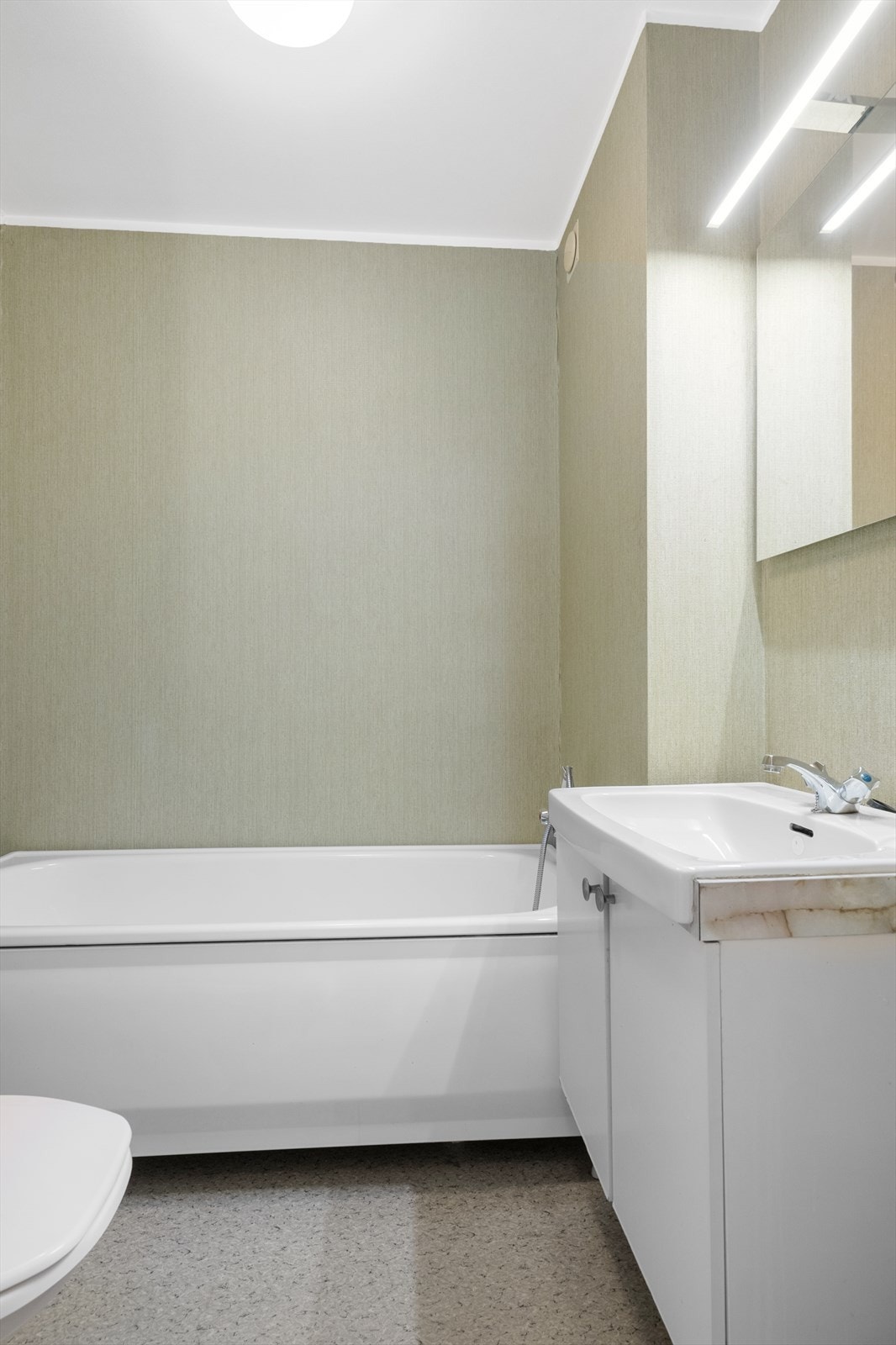 Badet i 2. etasje innehar standard fra byggeår, utstyrt med gulvmontert toalett, badekar og servantskap. Nyere speil og overlys på vegg. Galleribilde