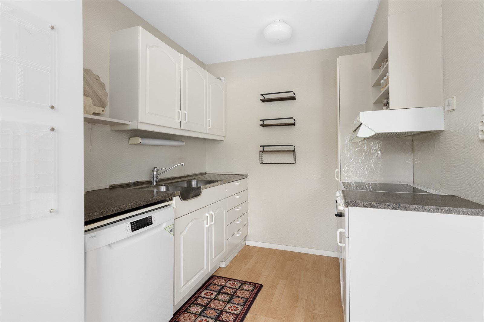 Kjøkkenet har eldre kjøkkeninnredning av ukjent alder, med profilerte fronter og laminat benkeplate. Heltrukket benkebeslag i rustfritt stål. Galleribilde