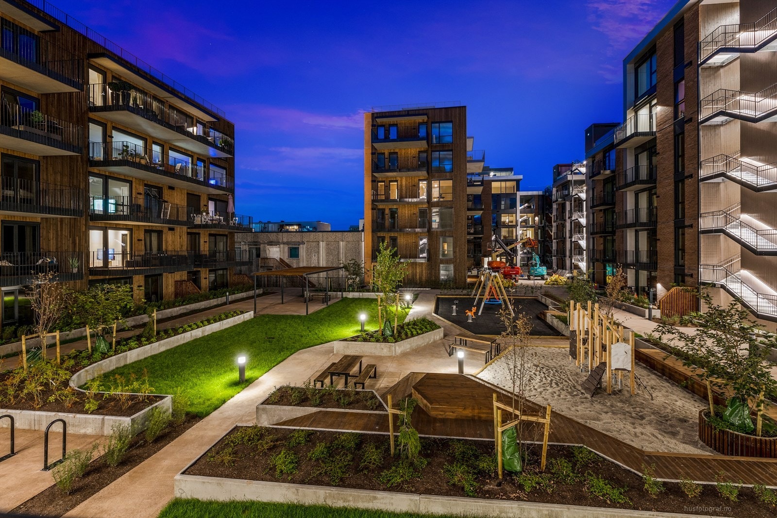 Fellestomten er pent anlagt med plen, store plantekasser, prydtrær, plattinger, lekeplasser og brede gangstier. Galleribilde