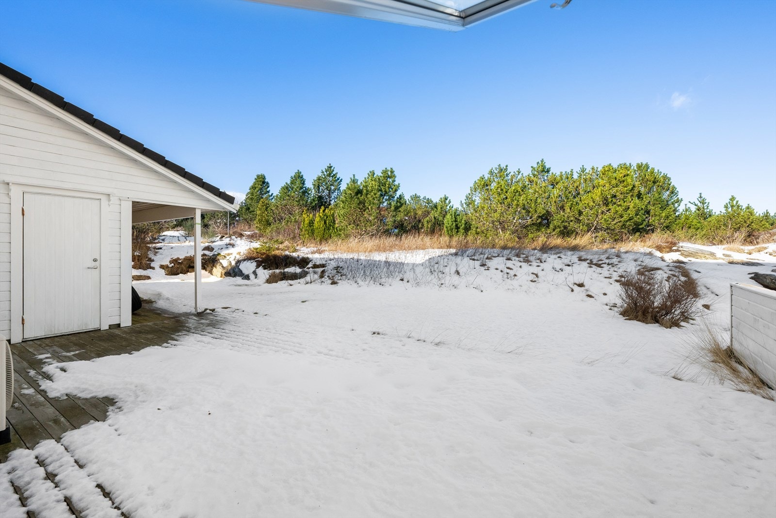 Stor uteplass på bakside med både treterrasse og gressplen Galleribilde