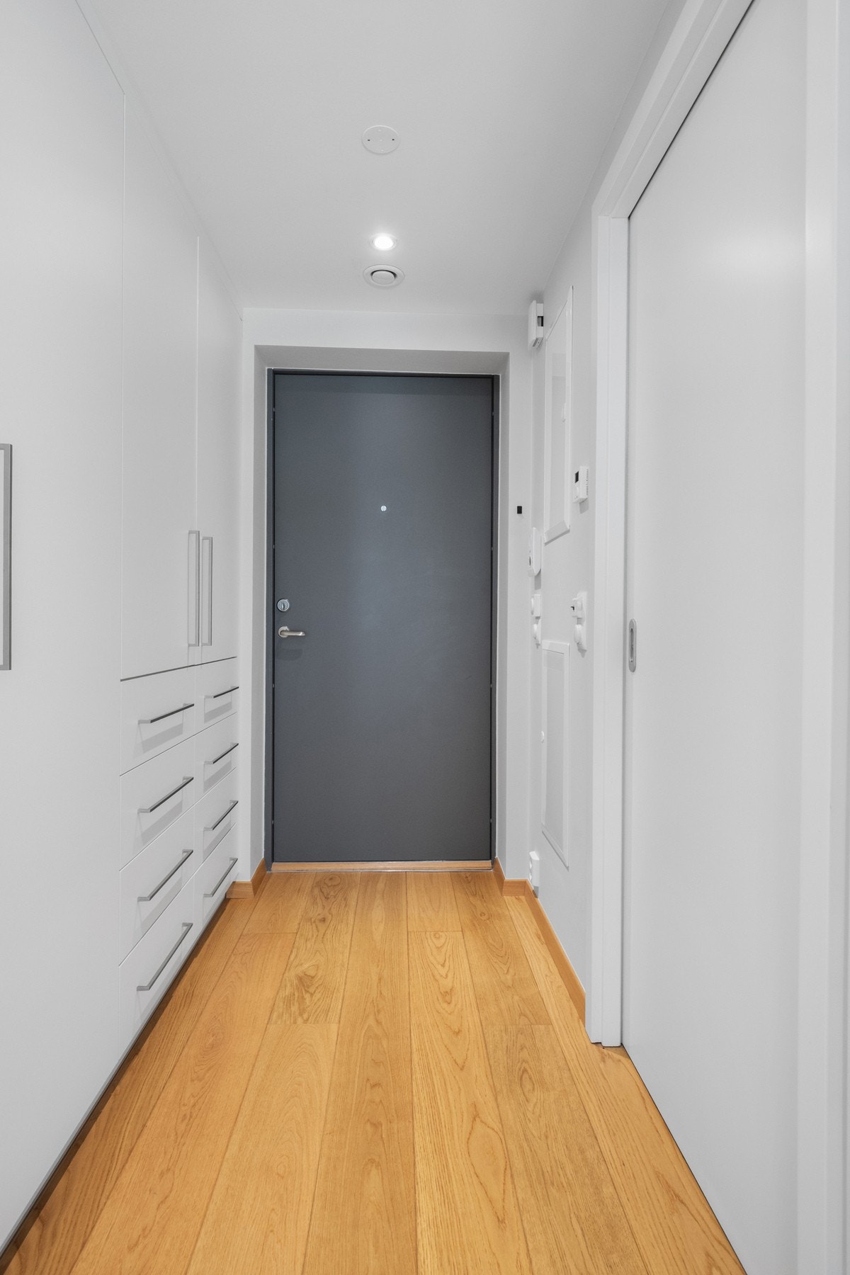 Entré med parkett på gulv og malte plater på vegger og tak. Boligen har malte, glatte dører som gir et helhetlig og moderne uttrykk. Galleribilde