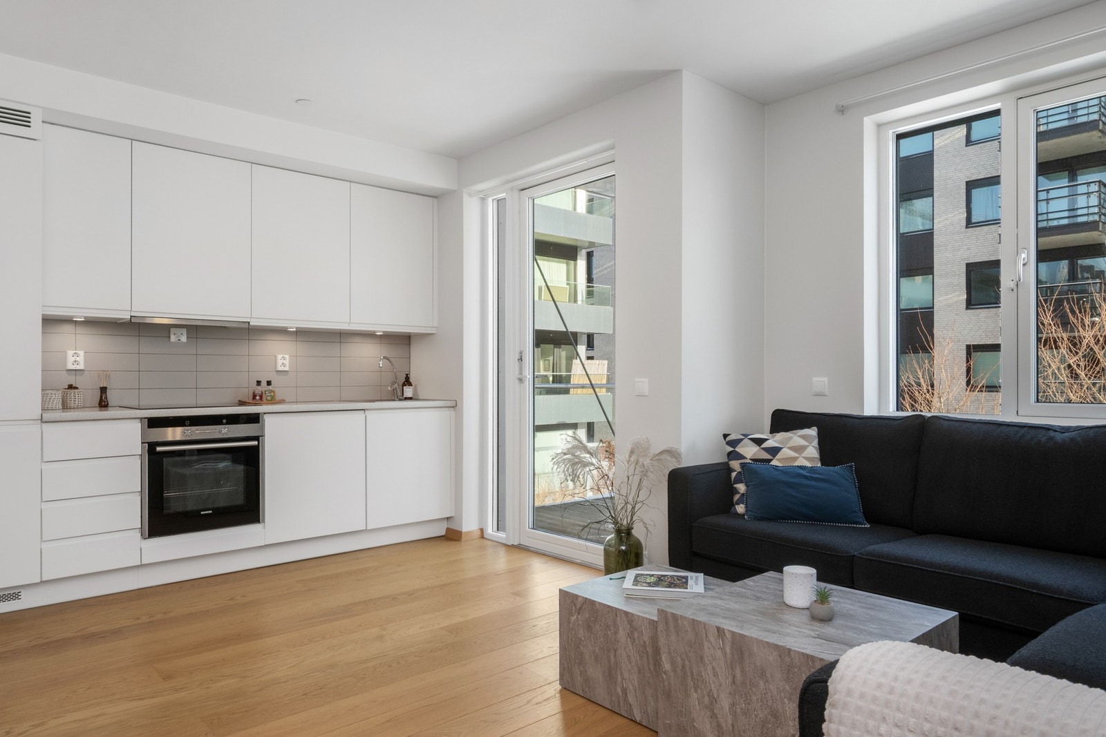 Leiligheten har åpen løsning mellom stue og kjøkken. Overflatene består av parkett på gulv og malte plater på vegger og tak. Galleribilde