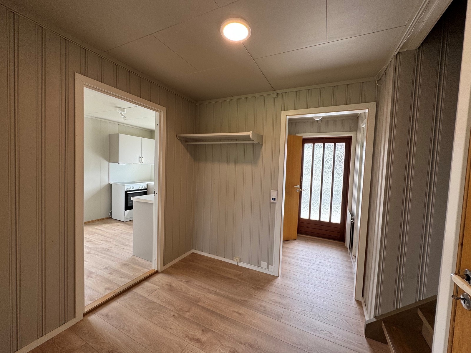 Romslig gang med dører inn til WC-rom, vaskerom og videre inn i boligen. Galleribilde