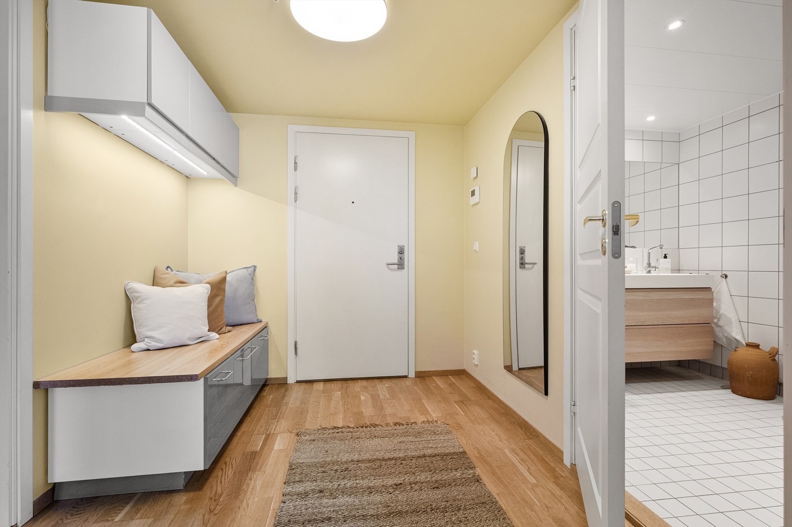 Velkommen inn i en lys entré med praktisk benk og oppbevaringsløsning. Galleribilde