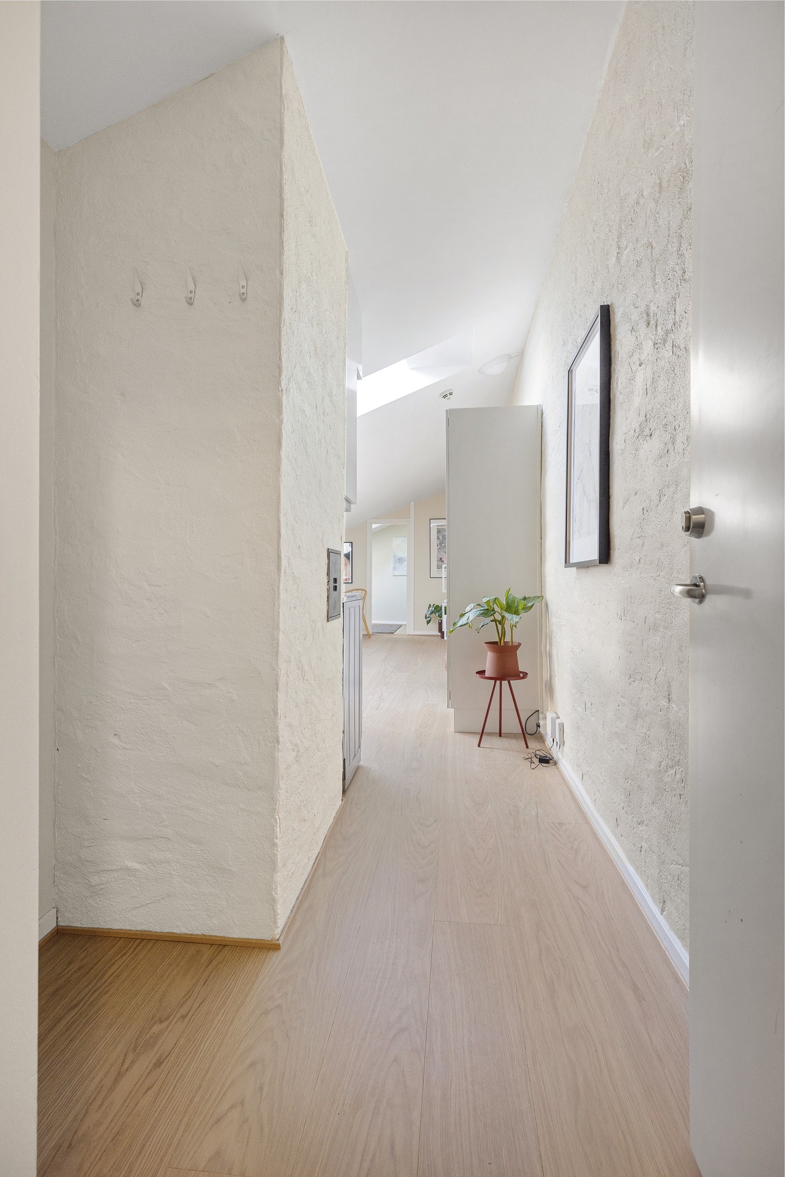 Entréen har lysmalte overflater og lekker parkett fra 2025. Galleribilde