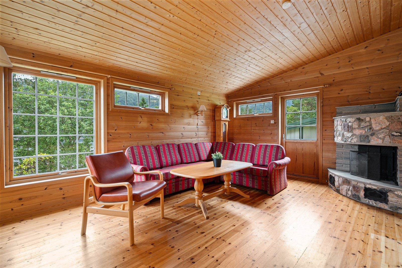 Hytta ble tilbygd i 1989 med stue, bad og soverom. Her er det en flott peis som bidrar til ekstra god varme på de kaldeste dagene. Galleribilde