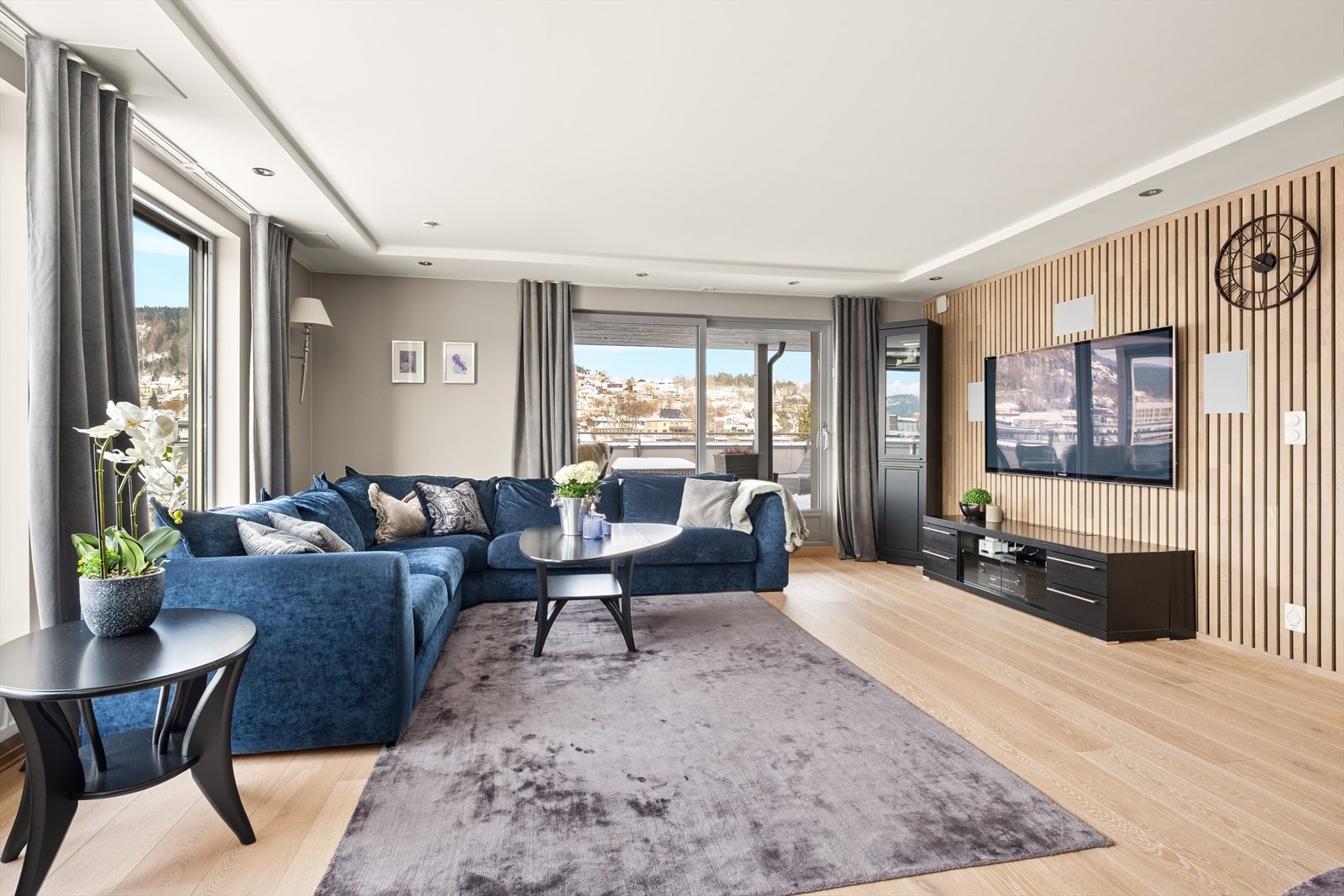 Bak TV-en i stuen finner du en moderne og dekorativ spilevegg med integrerte høyttalere. Galleribilde