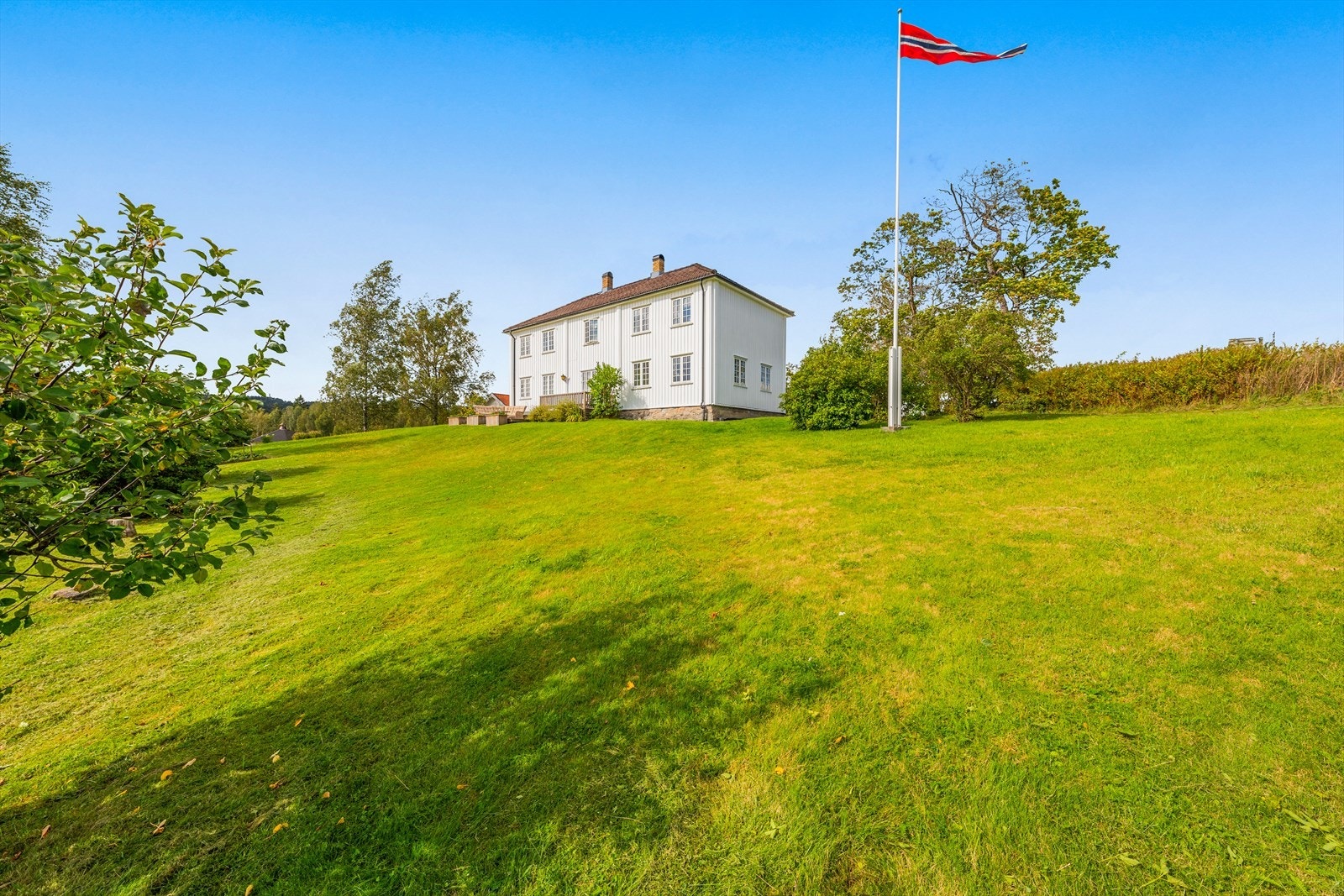 Flaggstang med vimpel på eiendommen. Galleribilde