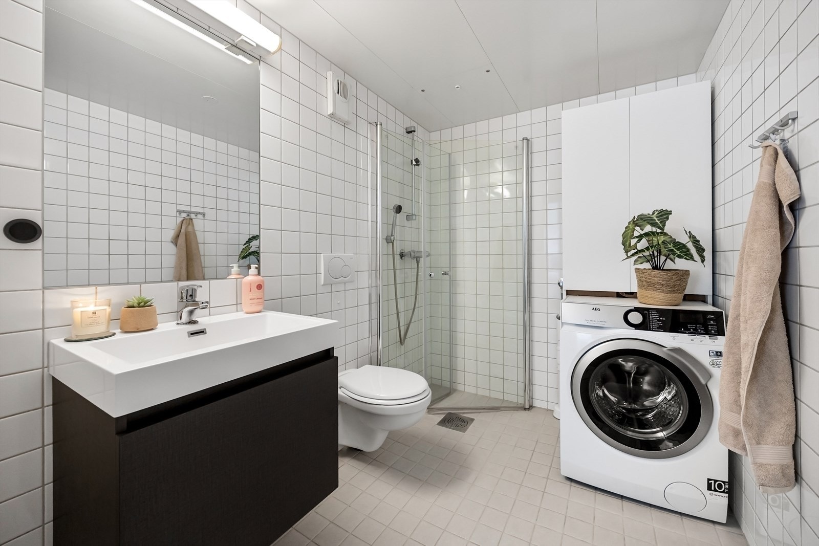 Baderomsinnredning bestående av benkeskap og veggskap, samt opplegg til vaskemaskin. Galleribilde