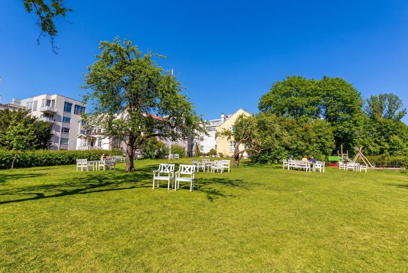 Idyllisk og frodig privat hage med store grøntområder og flere sittegrupper. Galleribilde