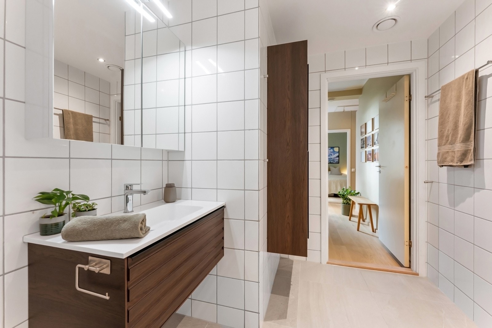 Innredningen består av heldekkende servant på skuffeseksjon og speilskap med belysning - Skap på vegg som gir ekstra oppbevaringsplass for baderomsartikler. Galleribilde