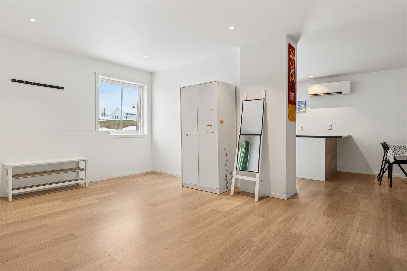 Gjennomgående laminatgulv og lyse, malte flater skaper en helhetlig og tidsriktig ramme. Galleribilde