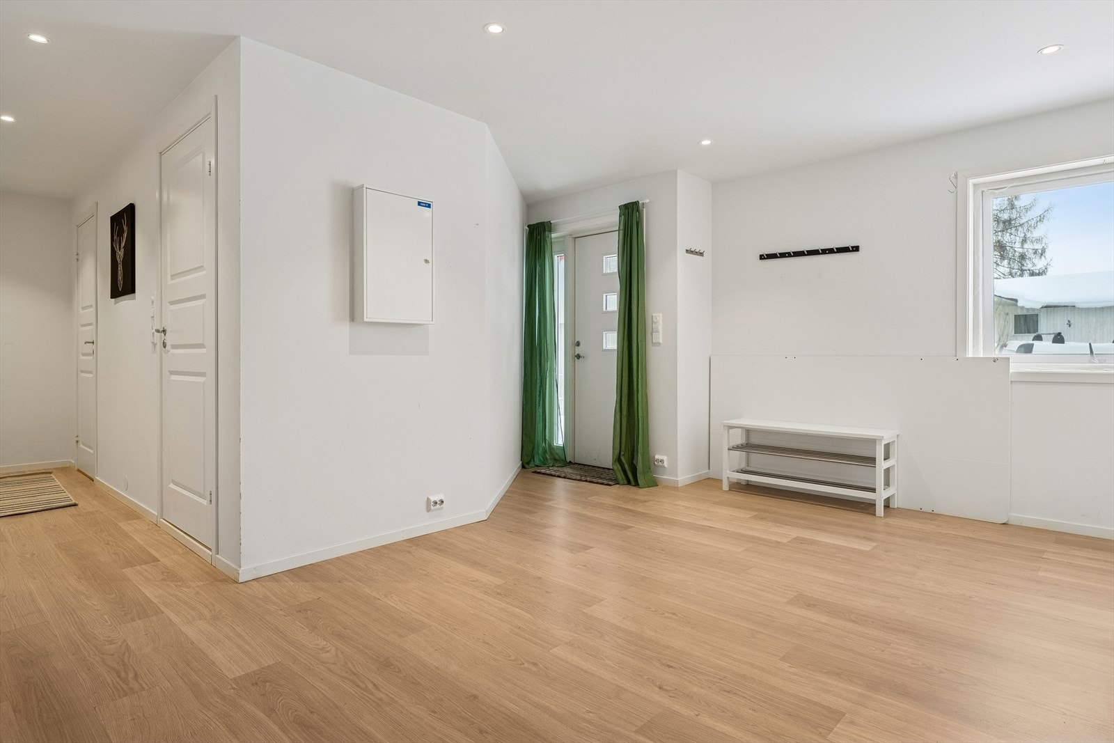 Velkommen inn i en romslig gang som binder boligens rom sammen på en effektiv måte. Galleribilde