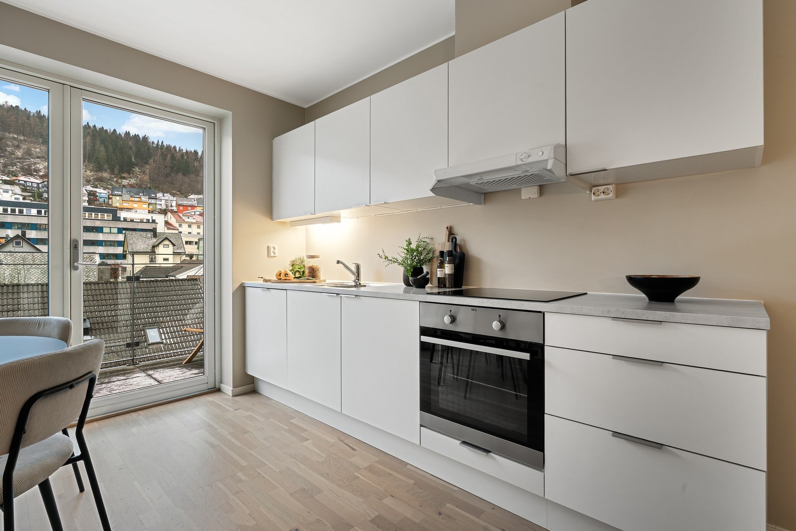 - Kjøkkeninnredningen med hvite fronter og laminat benkeplate - Galleribilde