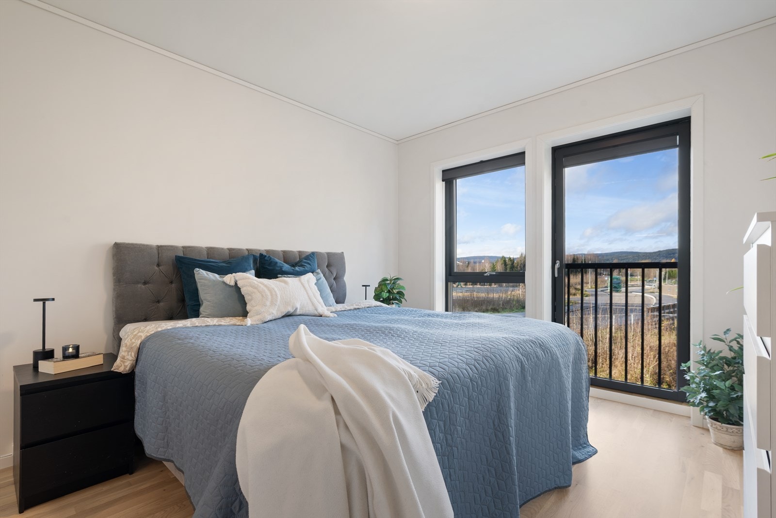 Lyst og romslig hovedsovreom med plass til dobbeltseng og tilhørende møblement Galleribilde