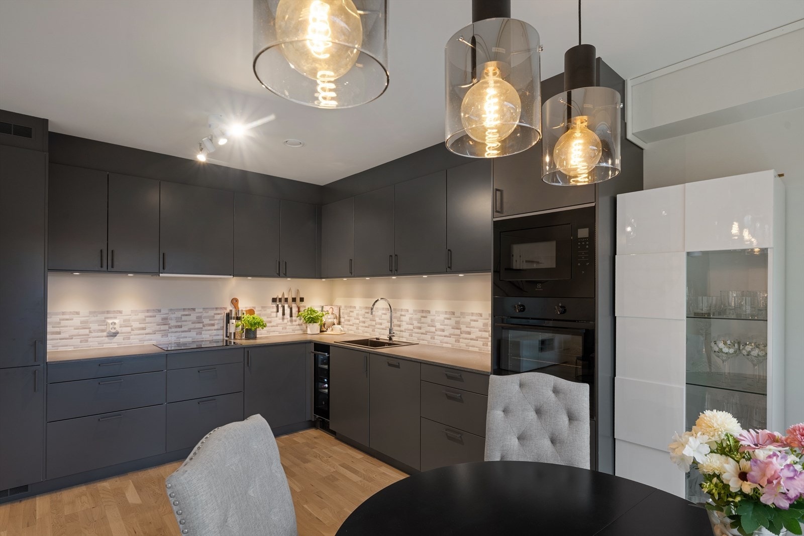 Moderne kjøkken i en praktisk L-form, med mørke fronter og stilfulle detaljer Galleribilde