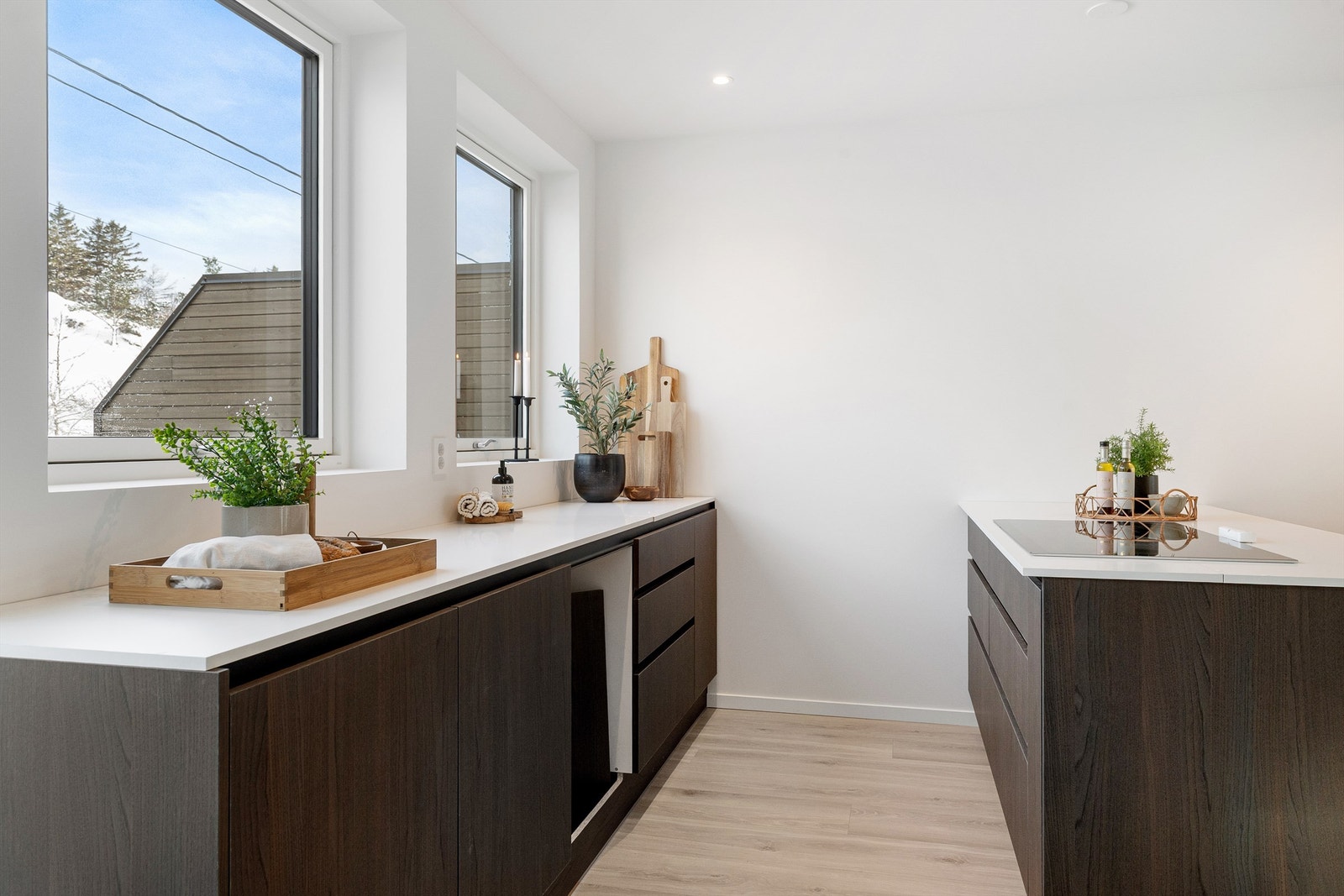 Praktisk arbeidskjøkken med rikelig skapplass og store vinduer som gir godt med dagslys. Galleribilde