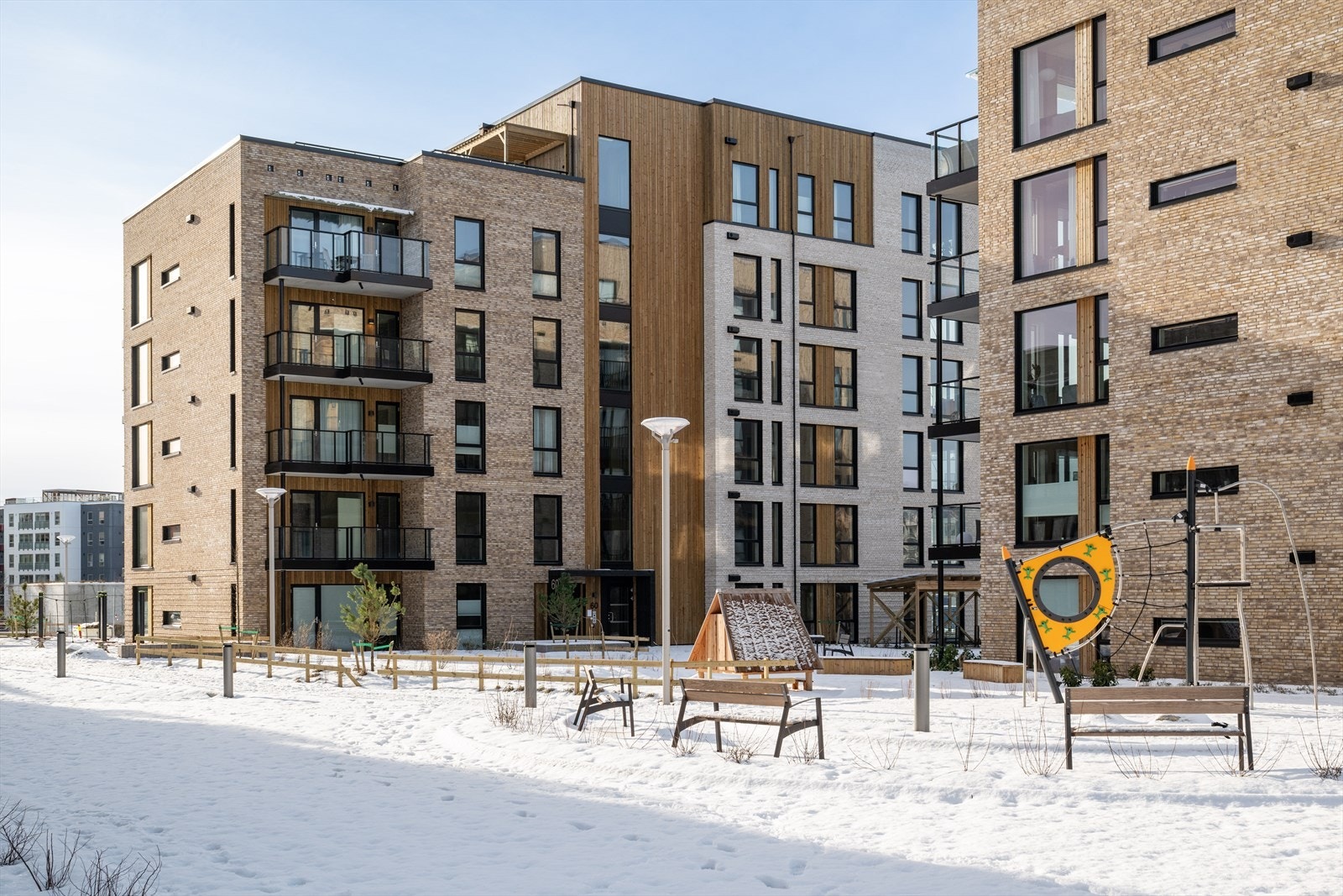 Pent opparbeidet og trafikkskjermet gårdsrom med sitteplasser og lekearealer. Galleribilde