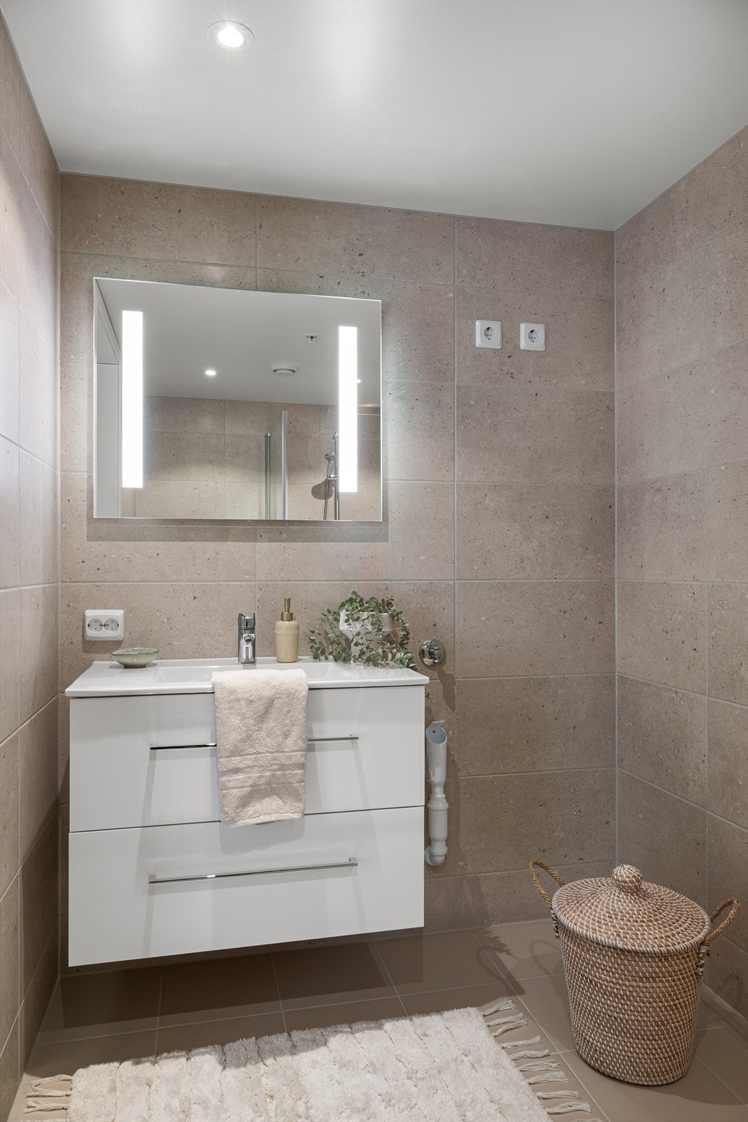 Delikat bad med vegghengt innredning og integrert speilbelysning. Galleribilde