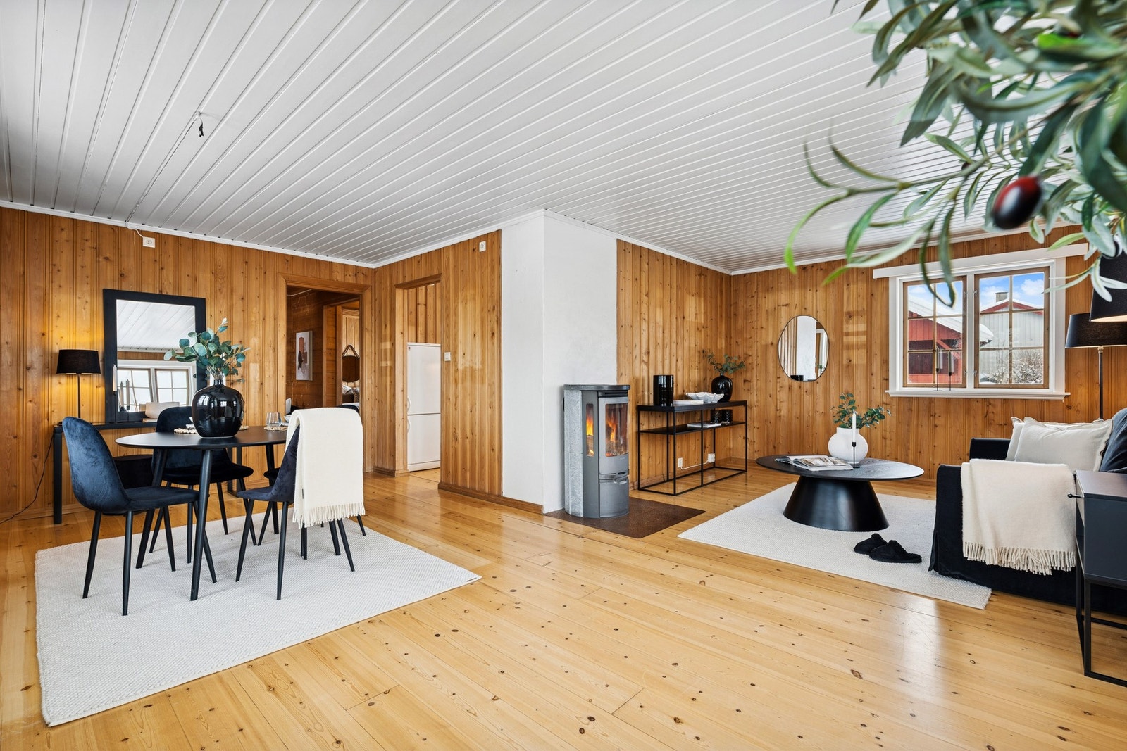 Lys og romslig stue med naturlig inndeling mellom spiseplass og sofagruppe. Galleribilde