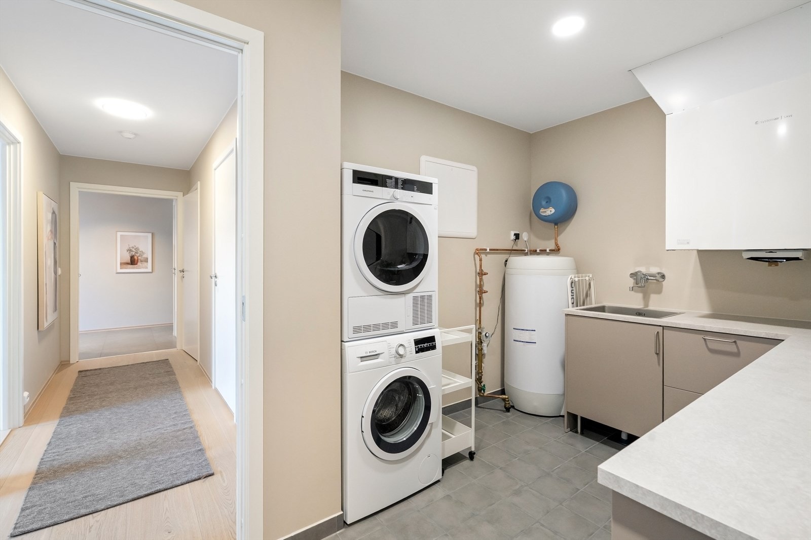 Vaskerom med gjennomtenkte løsninger som gjør hverdagen enklere. Her er det god skapplass, benkeplate, utslagsvask og opplegg til vaskemaskin. Galleribilde