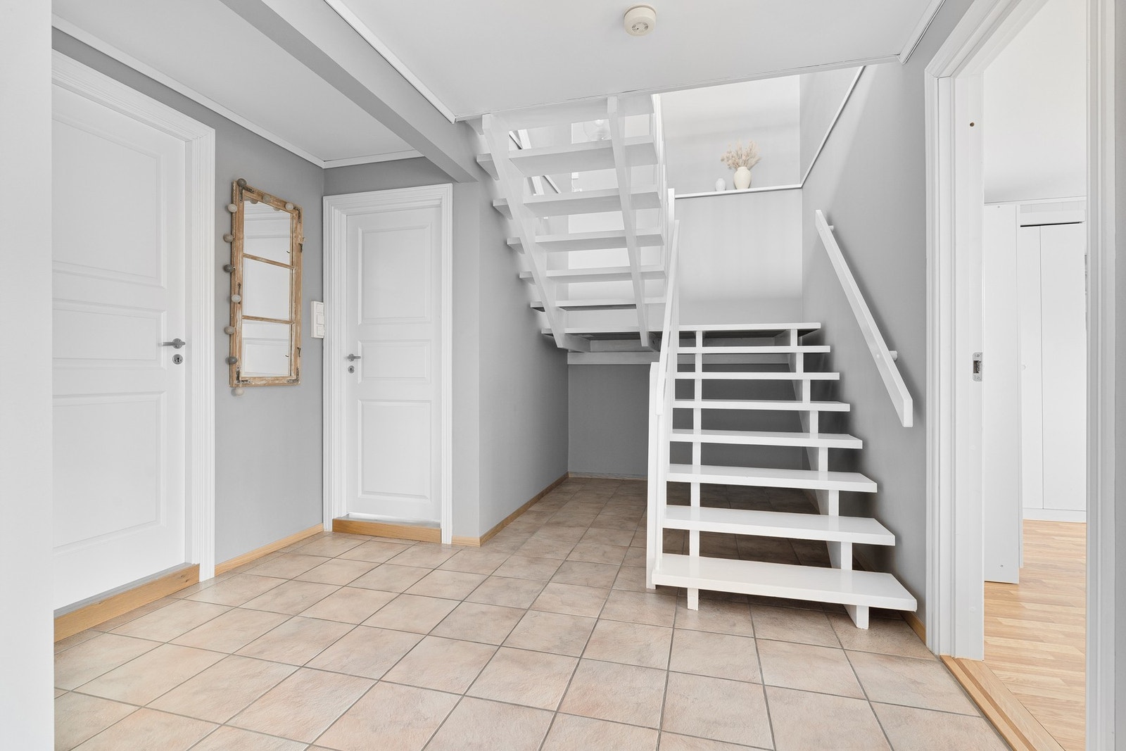 Romslig trappegang som knytter alle rom i underetasjen. Galleribilde