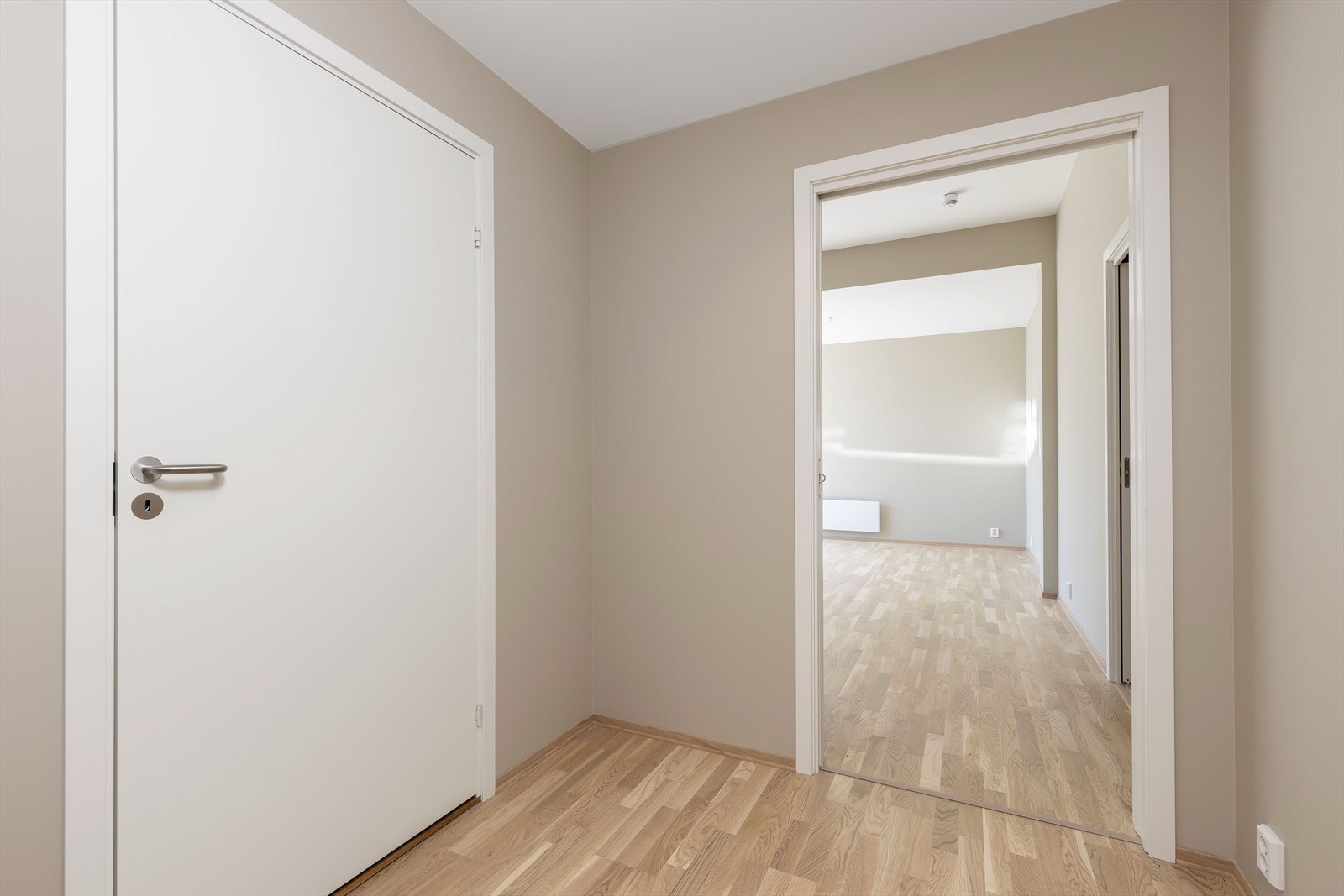 Entreen er romslig og kommer med en skyvedørsgarderobe, med god plass til oppbevaring Galleribilde