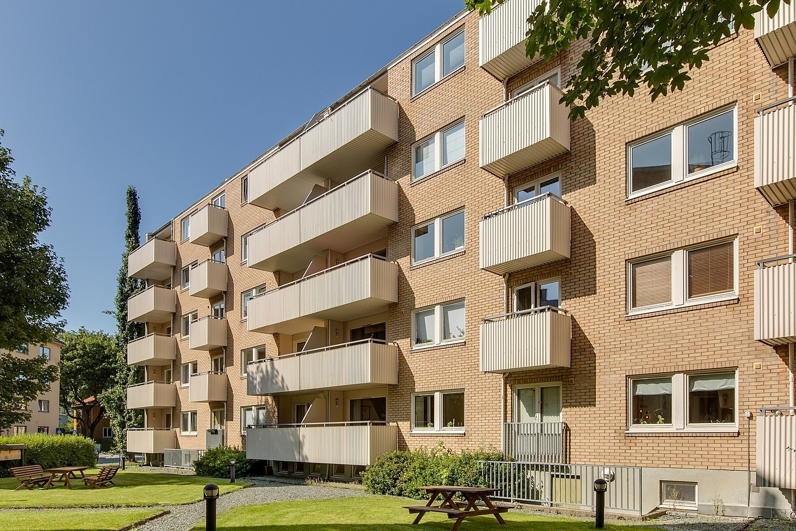 Borettslagets frodige bakgård disponeres fritt av beboerne, med felles benker og grill inkludert. Galleribilde