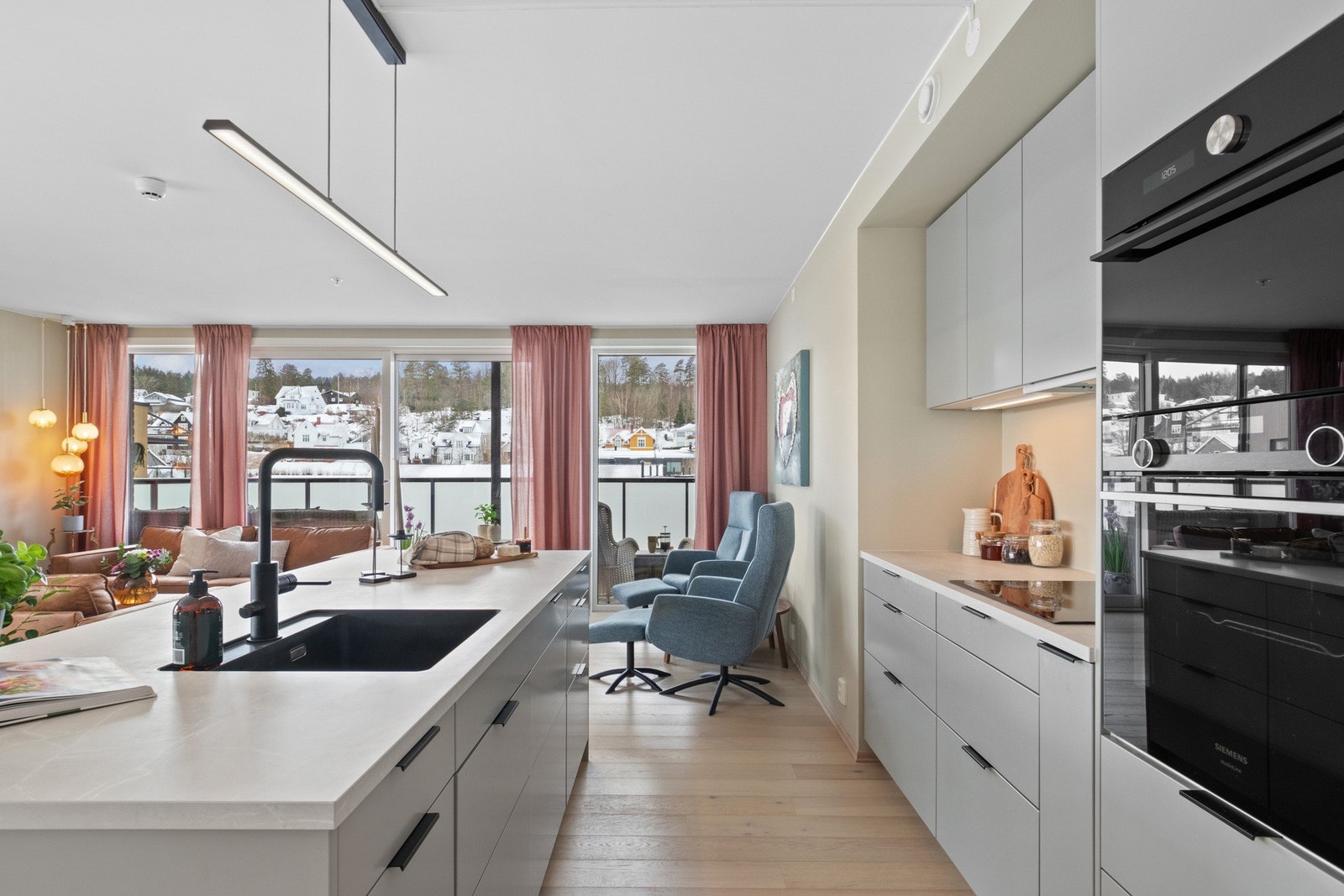 Kjøkkenet er levert av Drømmekjøkkenet og har en gjennomført og moderne innredning med veggseksjon, høyskap og romslig kjøkkenøy. Løsningen gir gode arbeidsflater samt rikelig med skap- og skuffeplass. Galleribilde