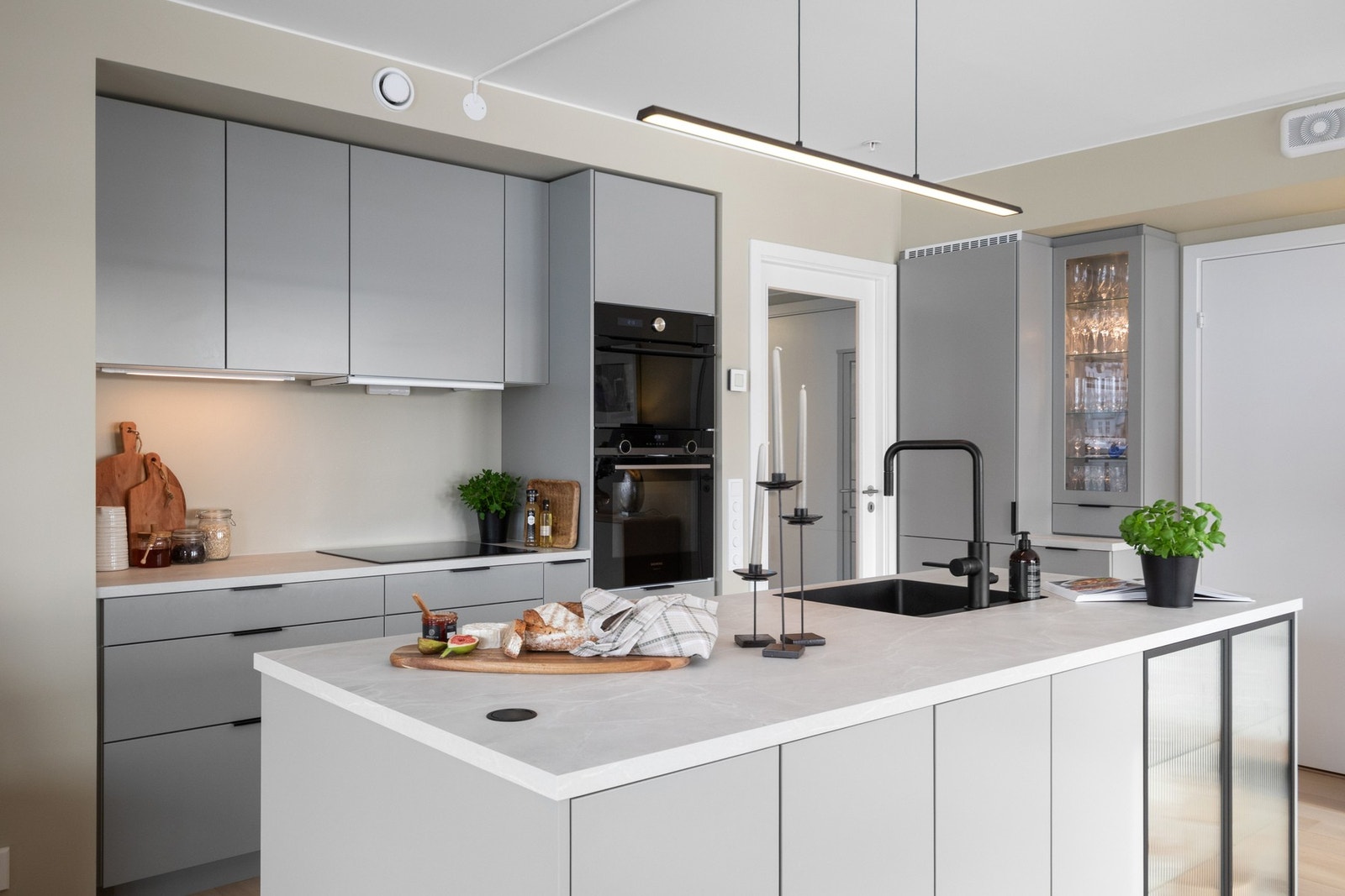 Kjøkkenøya er utstyrt med nedfelt sort oppvaskkum, sort armatur og praktisk pop-up stikkontakt, og fungerer som et naturlig samlingspunkt i rommet. Galleribilde