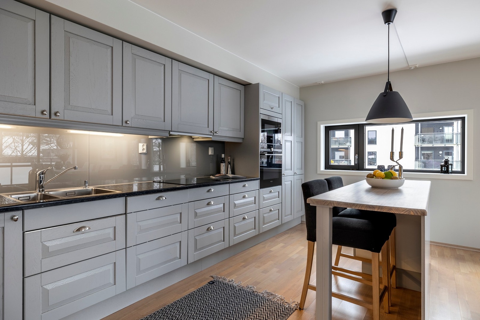 Mot stuen er det en praktisk kjøkkenøy med laminerte benkeplater som både gir en ekstra arbeidsplass og en hyggelig sitteplass. Galleribilde