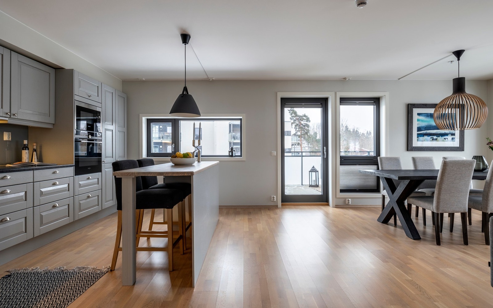 Moderne Sigdal-kjøkken med grå profilerte fronter og stein benkeplater med nedfelt oppvaskkum. Galleribilde