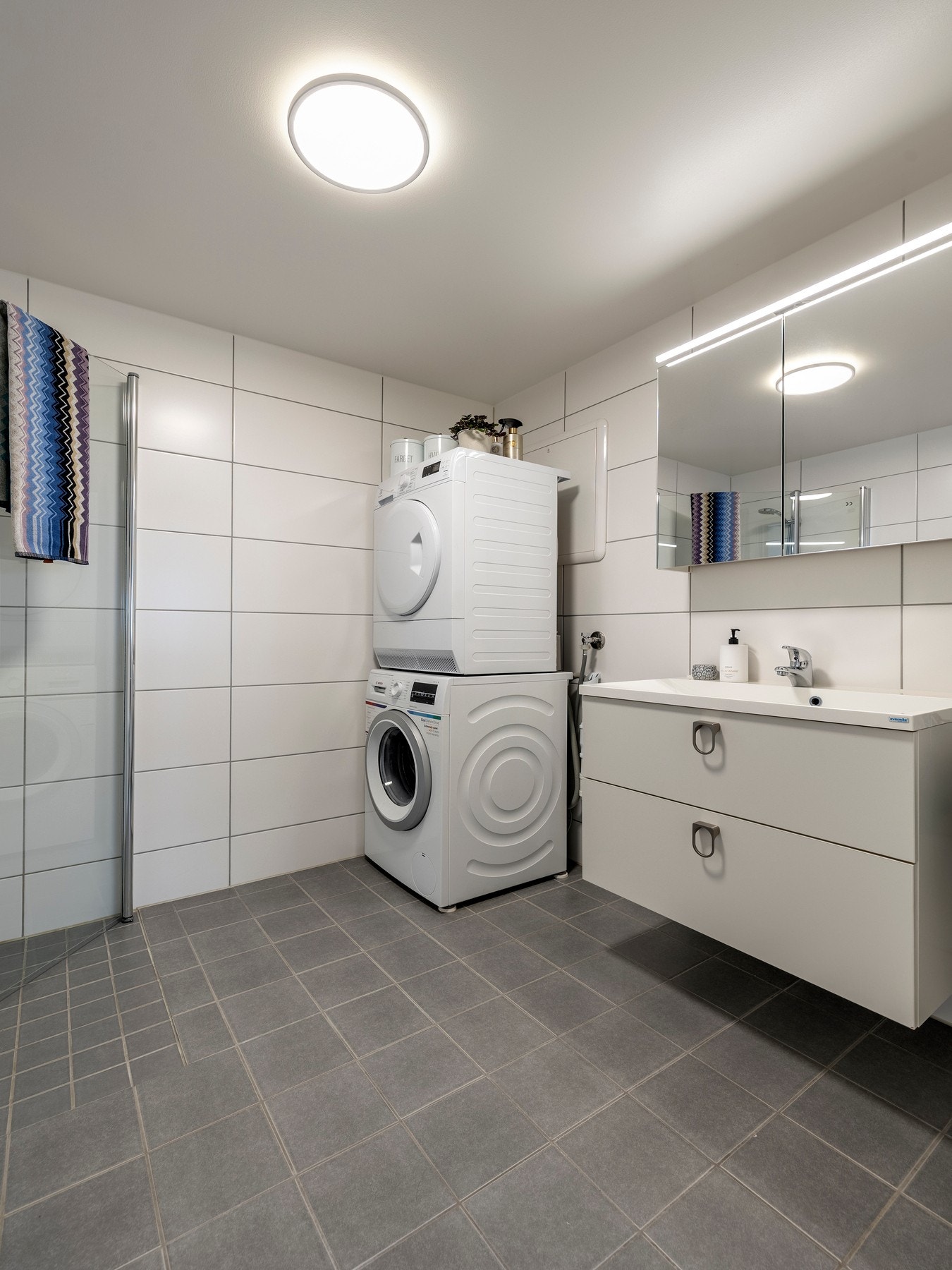 Badet har et pent uttrykk med flislagte vegger og flislagt gulv med elektriske varmekabler. Galleribilde