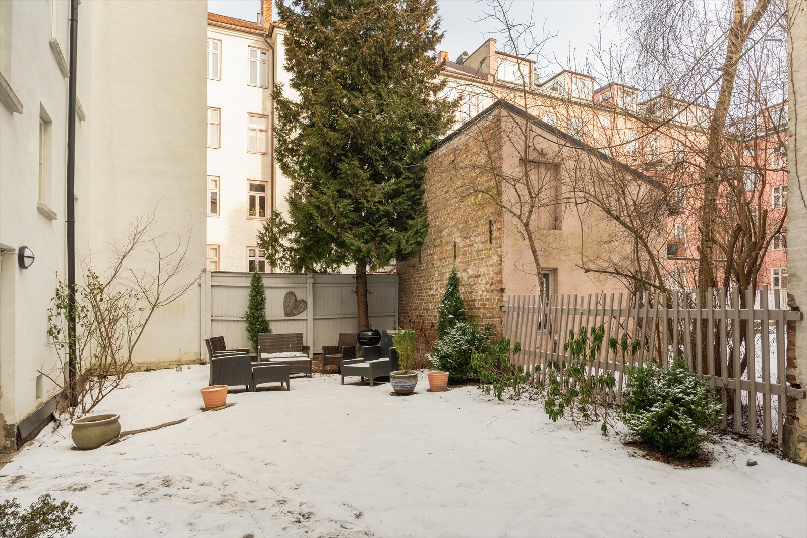 Hyggelig og frodig felles bakgård med utemøbler Galleribilde