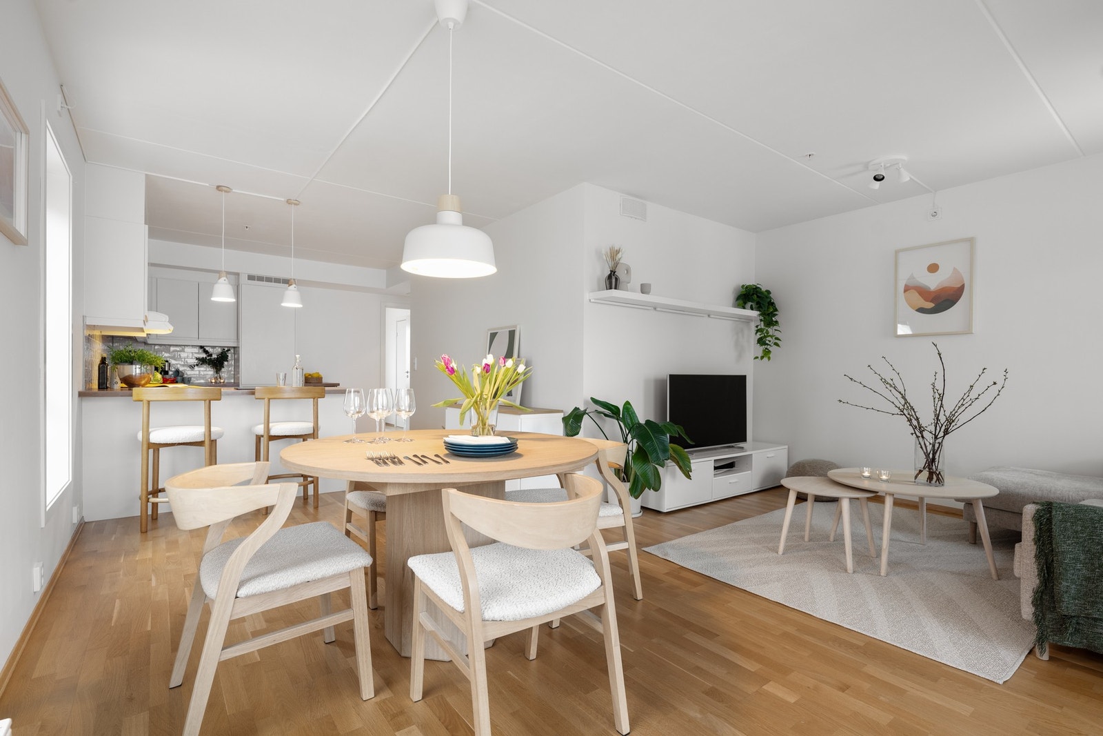 Oppholdsrommet med stue og kjøkken i åpen løsning med fone soner Galleribilde