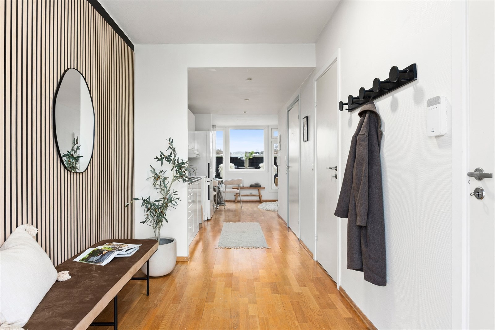 Fra inngangspartiet åpner leiligheten seg opp mot stue og kjøkken. Galleribilde