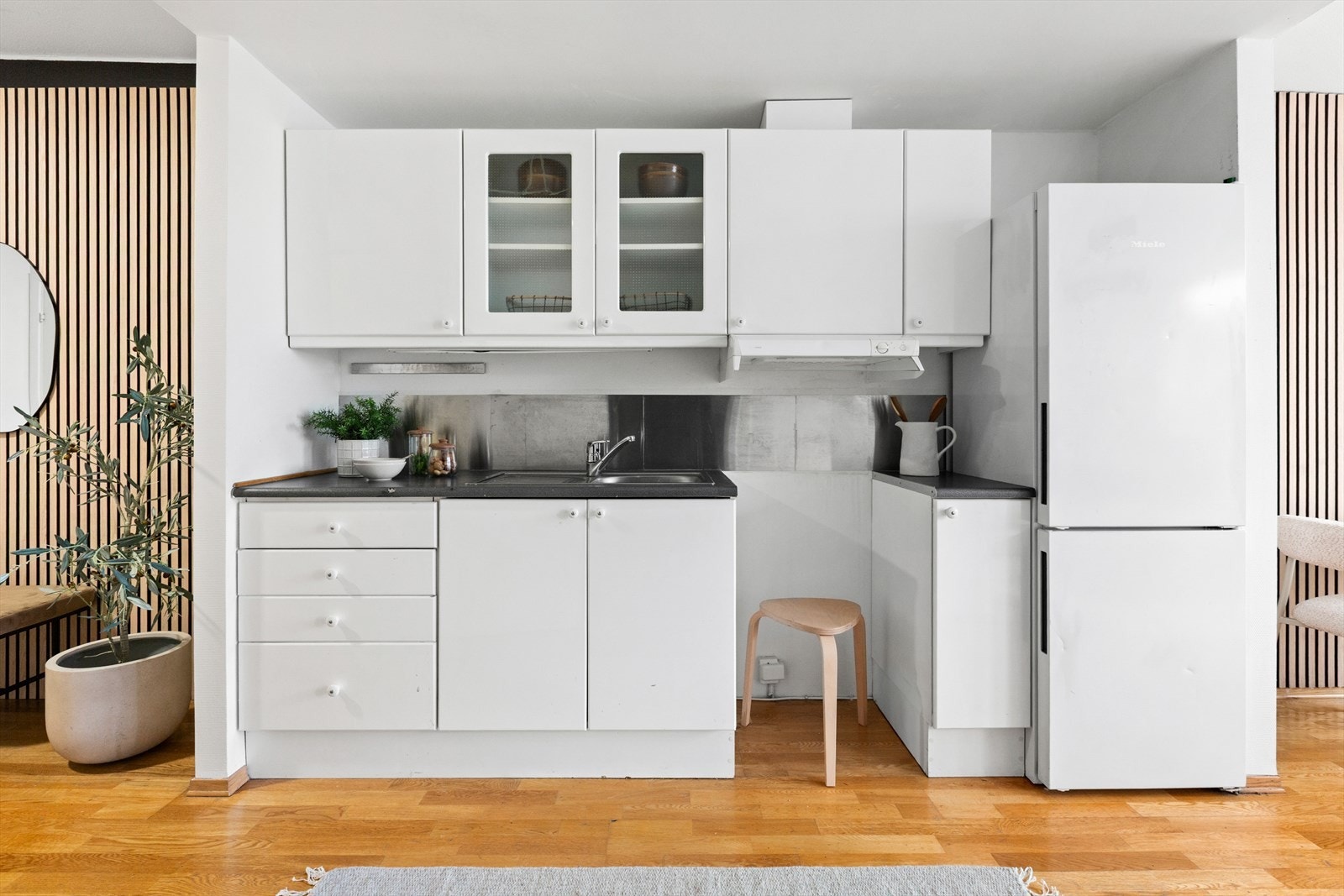 Kjøkkeninnredning med slette fronter, laminatbenkeplate og ventilator med avtrekk ut. Galleribilde