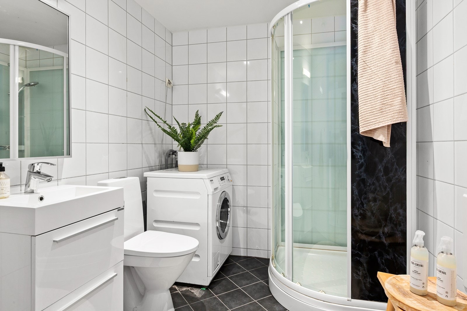 Flislagt bad med elektrisk gulvvarme, dusjkabinett og opplegg for vaskemaskin. Galleribilde