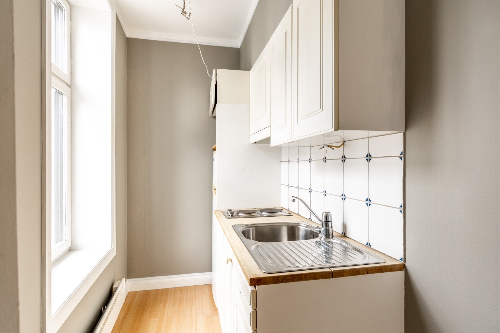 Kjøkken har innredning bestående av glatte fronter og laminat benkeplate, samt delvis integrerte hvitevarer som kjøl/fryseskap (frittstående) og platetopp Galleribilde