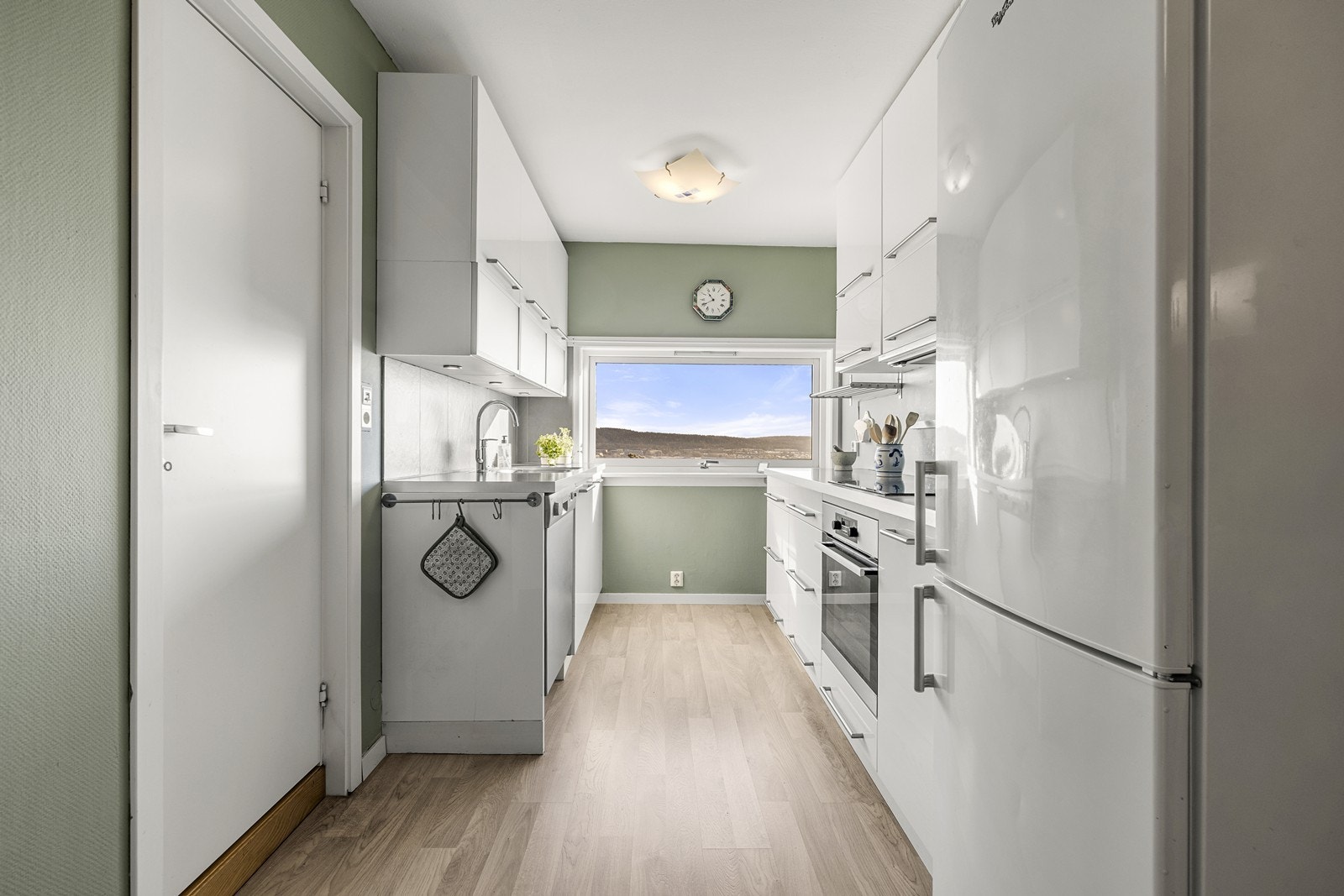 Kjøkkeninnredningen har slette høyglansfronter som gir et rent og tidløst uttrykk. Galleribilde