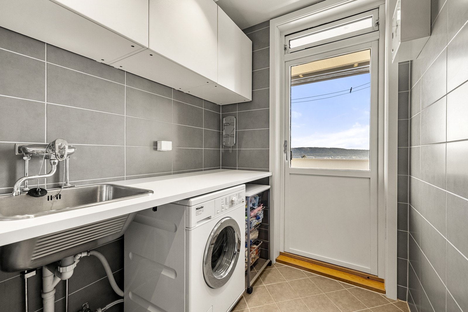 En egen vaskeromsdel er praktisk innredet med utslagsvask og opplegg for vaskemaskin. Galleribilde