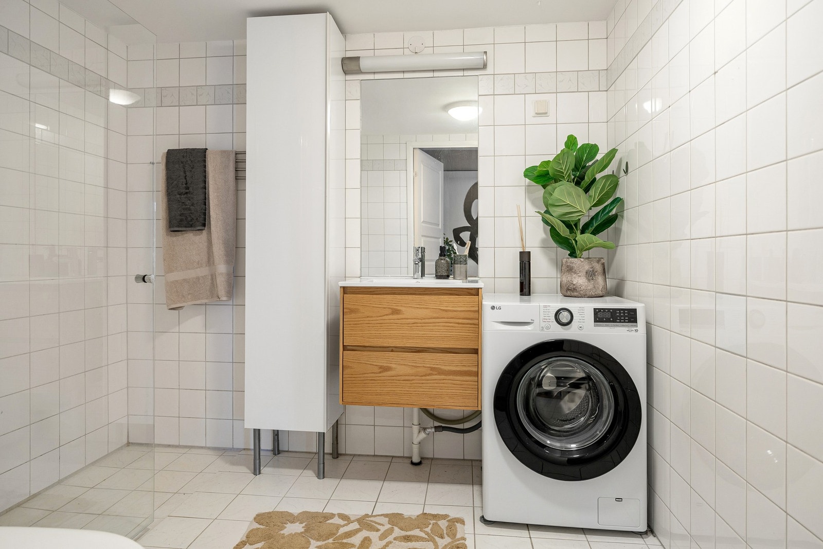 Stort og pent flislagt bad med varmekabler i gulv og opplegg for vaskemaskin. Galleribilde