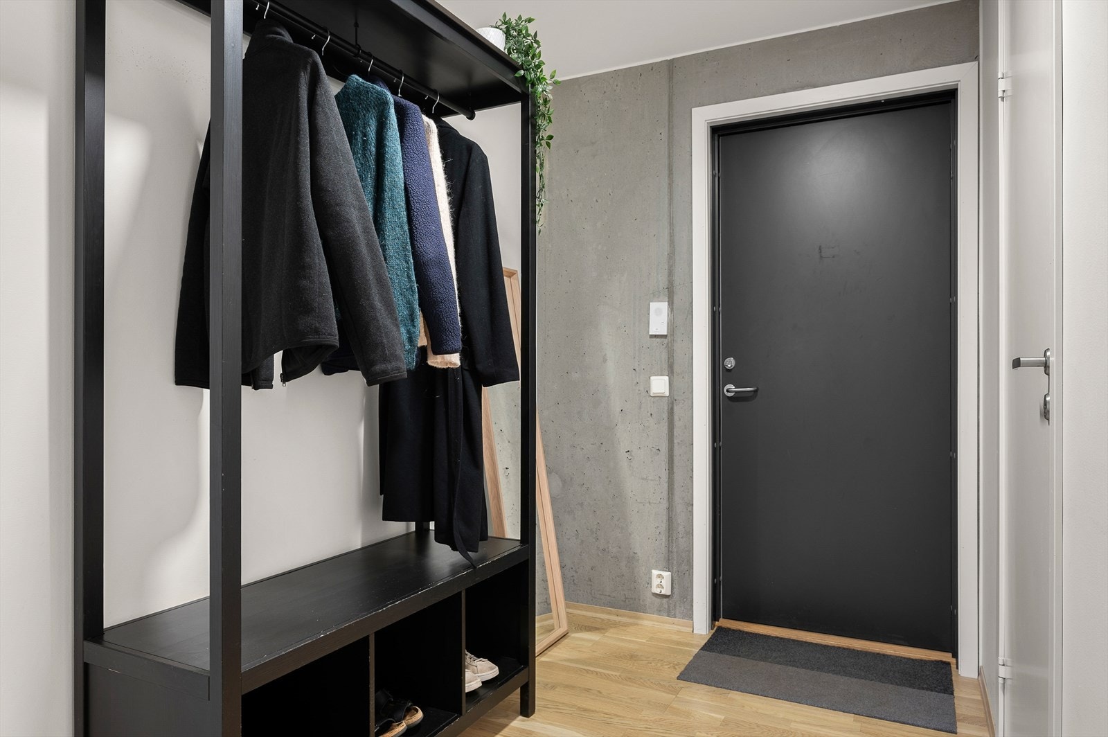 Med unntak av baderommet er det parkett på gulv i hele leiligheten. Den ubehandlede betongveggen fungerer som en flott kontrast til boligens lyse farger. Galleribilde