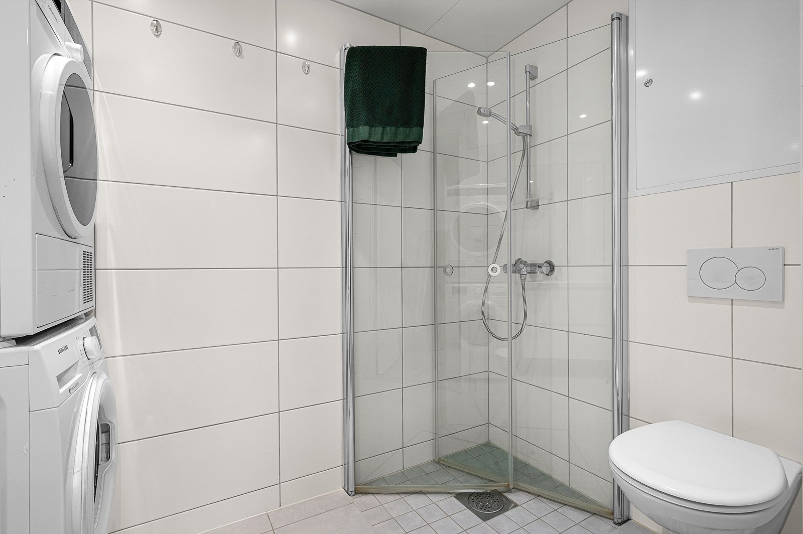 Rommet for velvære er videre utstyrt med dusjhjørne, mekanisk avtrekk, opplegg for vaskemaskin, rørfordelingsskap, servant, servantskap, veggmontert wc, stoppekran og vannmåler Galleribilde