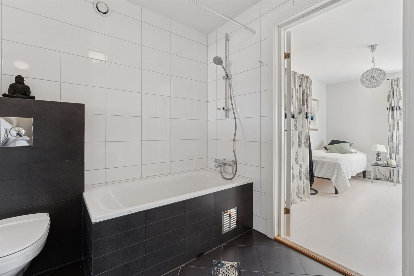 Rommet er utstyrt med innmurt badekar, veggmontert klosett og varmekabler i gulvet. Galleribilde